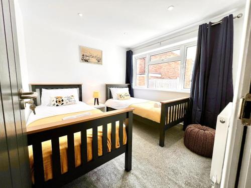 a bedroom with two beds and a window at 4 Bedroom Detached Hse, 102 sq mtrs, with 2 Bathrooms, 3 Toilets and Free Parking in Hemel Hempstead