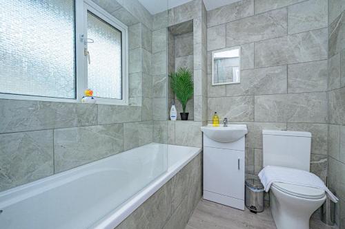 a bathroom with a tub and a toilet and a sink at 4 Bedroom Detached Hse, 102 sq mtrs, with 2 Bathrooms, 3 Toilets and Free Parking in Hemel Hempstead