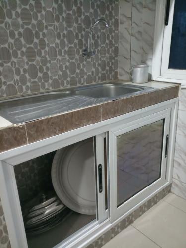 a kitchen with a sink and a plate under it at S I Appartements in Dakar