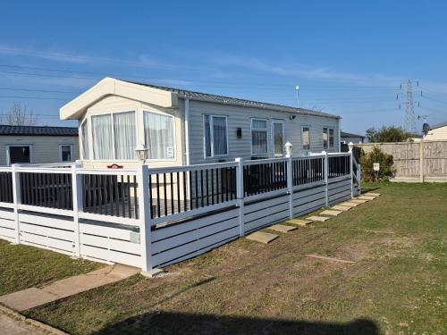 a house with a white fence in a yard at Birchington Vale - 2 Bedroom Holiday Home in Margate