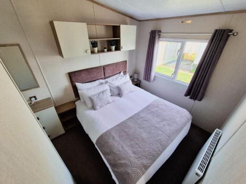 a small bedroom with a bed and a window at Birchington Vale - 2 Bedroom Holiday Home in Margate