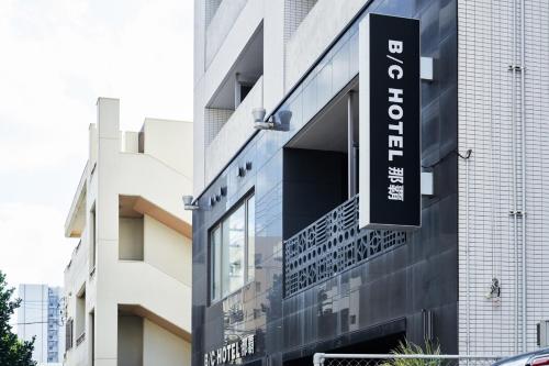 a building with a sign on the side of it at BbyC Hotel 那覇 レンタカー付ホテル in Naha