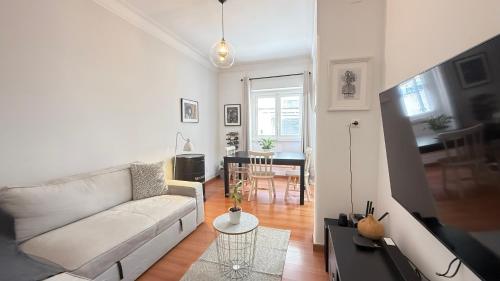 a living room with a white couch and a table at Alameda Urban Room in Lisbon