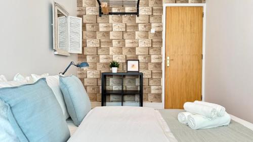 a bedroom with a bed and a brick wall at Alameda Urban Room in Lisbon