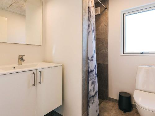 Un baño con lavabo, inodoro y ventana. en 5 star holiday home in Humble, en Humble