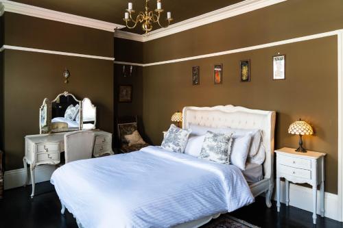 a bedroom with a white bed and a chandelier at Bohemian Retreat by the Sea with wood burner, roll-top bath & leafy garden in Margate