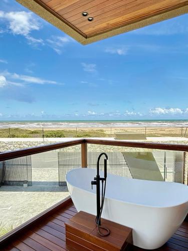 a bath tub on a balcony with a view of the beach at Villa Prime Beach Flats in Aracaju