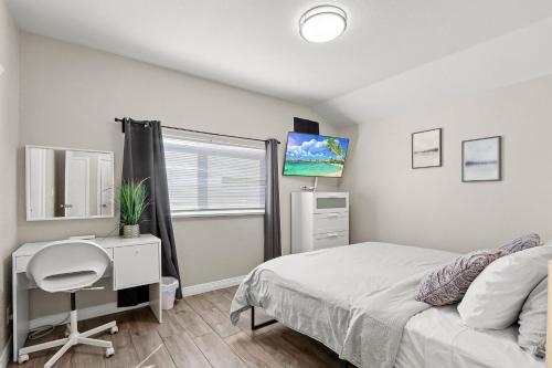 a bedroom with a bed and a desk and a tv at Renovated Stay, Parking, Near DT & Airport in El Paso