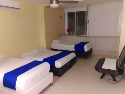 a room with two beds and a chair in it at Toscana Suite 3009 in Las Margaritas