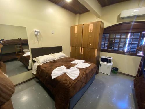 a bedroom with a bed with two white towels on it at Apartamentos Gramado Centro - Localizados Próximo a Rua Coberta in Gramado