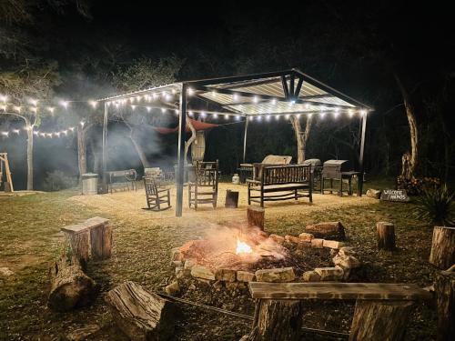 a fire pit in front of a tent at night at Tiny house - Our little piece of paradise in Lakehills