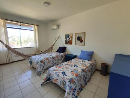 ein Schlafzimmer mit zwei Betten und einer Hängematte darin in der Unterkunft Casa Aconchego in Aracaju