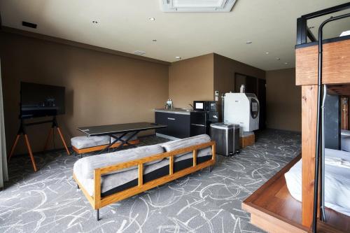 a room with two beds and a table in it at BbyC Hotel 那覇 レンタカー付ホテル in Naha