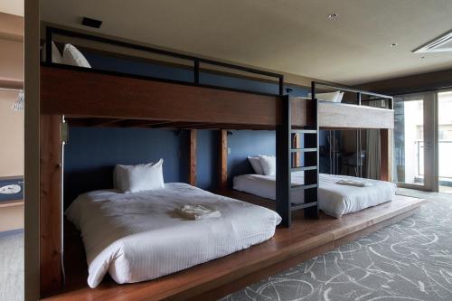 a bedroom with two bunk beds in a room at BbyC Hotel 那覇 レンタカー付ホテル in Naha