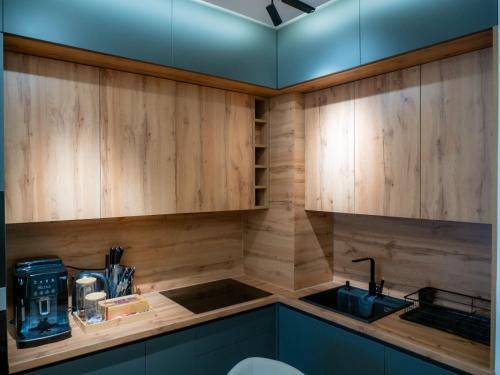 a kitchen with wooden cabinets and a sink at SnowLuxe Apartman Bjelašnica FREE GARAGE in Bjelašnica