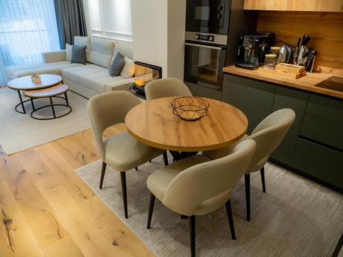 a kitchen and living room with a table and chairs at SnowLuxe Apartman Bjelašnica FREE GARAGE in Bjelašnica