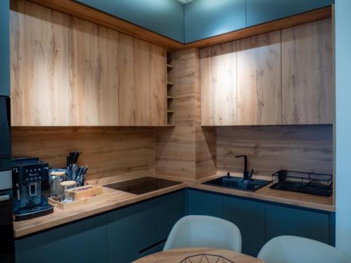 a kitchen with wooden cabinets and a sink at SnowLuxe Apartman Bjelašnica FREE GARAGE in Bjelašnica