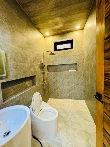 a bathroom with a toilet and a sink at Tomeizah in Sampong