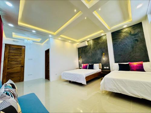 a hotel room with two beds and a ceiling at Tomeizah in Sampong