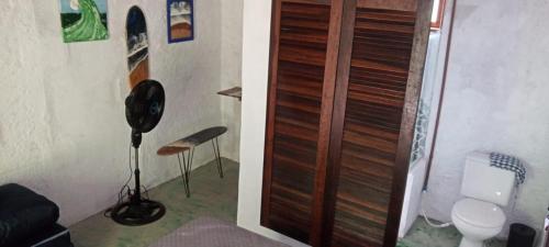 bagno con servizi igienici e porta in legno di Suítes Águas do Estaleiro a Ubatuba