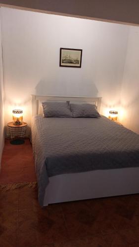 a bedroom with a large bed with two lamps at Olhinhos de Azeitona - Quatro Ribeiras in Praia da Vitória