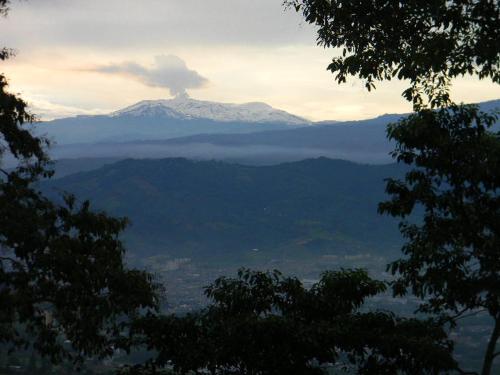 a view of a snow covered mountain in the distance at Finca Hotel Villa Ilusión in Pereira