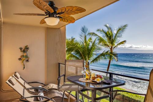 a balcony with a table and chairs and the ocean at Mahana 305 in Kahana