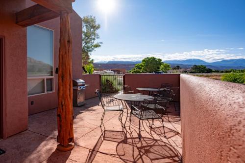 a patio with a table and chairs on a balcony at Moab Adventure Basecamp in Moab
