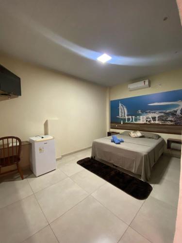 una camera da letto con un letto e una TV in una stanza di Pousada Capitão Leno a Miranda