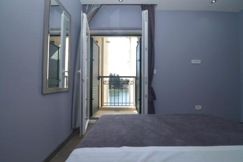 a bedroom with a bed and a door to a balcony at Pontus Luxury Apartments in Tivat