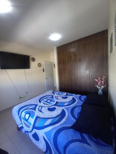 a bedroom with a bed with a blue blanket at Vista del Sol residence, pool, 3 parking spaces, 3 bedrooms, 2 bathrooms in Tlacote el Bajo