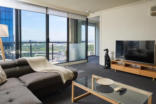 a living room with a couch and a tv at Exclusive Stays - Sentinel in Melbourne