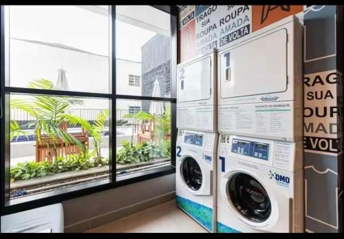 a laundry room with a washer and dryer next to a window at ZYZ - Centro in Sao Paulo