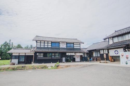 a building with a lot of windows on a street at 【佐渡/一棟貸切】オーシャンビュー古民家SeaSideStory椿 離れ in Sado
