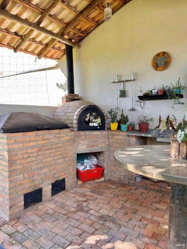 a brick oven in a patio with a table at Chácara Renil in Olímpia