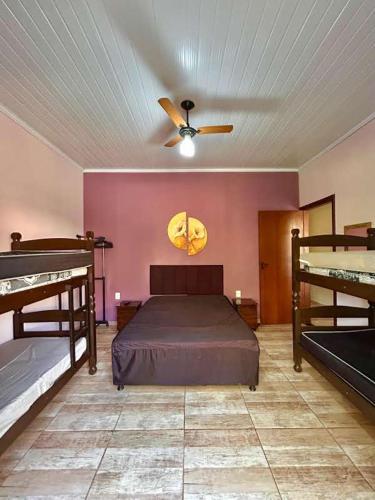 a bedroom with two bunk beds and a ceiling fan at Chácara Renil in Olímpia