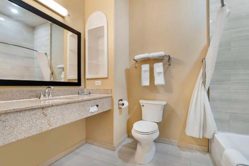 Un baño con inodoro, lavabo y bañera. en Best Western Hebbronville Inn, en Hebbronville
