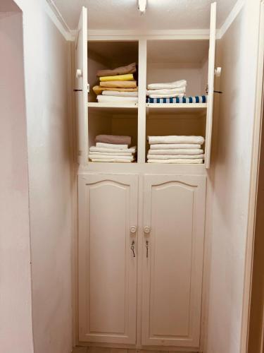 a closet with white cabinets and folded towels at Dan Beach Apartment in Trou dʼ Eau Douce