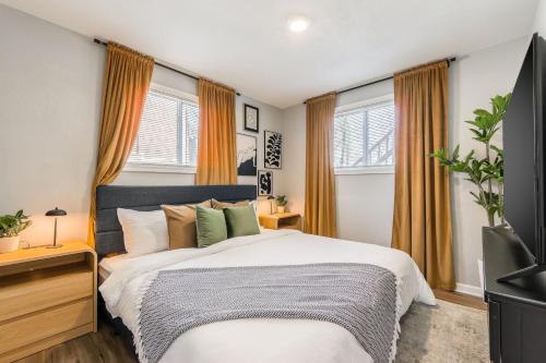 a bedroom with a large bed and windows at Home in Kansas City 15 mins to KCI with a KING bed and workspace in Riverside