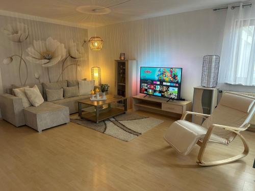 a living room with a couch and a flat screen tv at La Pura Vida in Bühlertann