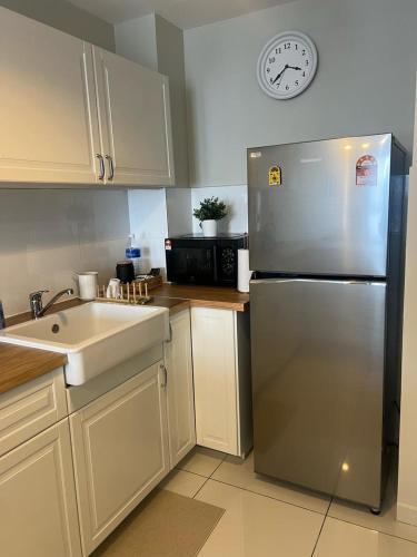 a kitchen with a stainless steel refrigerator and a clock at Mus Lim Mimi Homestay Gamuda Gardens in Rawang
