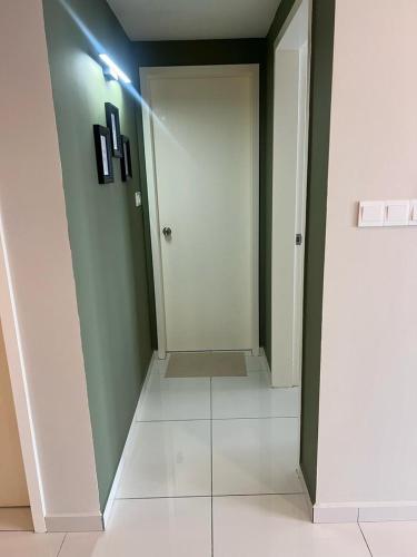 a hallway with a white door and a white tile floor at Mus Lim Mimi Homestay Gamuda Gardens in Rawang