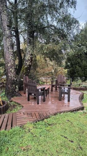 a group of benches and tables on a wooden deck at Wincarayen Lodge & Cabañas in Panguipulli