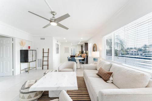 布卡拉顿Serene Waterfront 2BR 2BA with Intracoastal Views, Pool, Balcony, Parking的客厅配有白色家具和吊扇