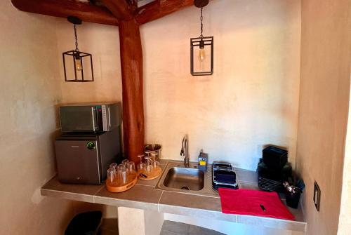 a small kitchen with a sink and a microwave at Cabanas Jaalkab in Chelem