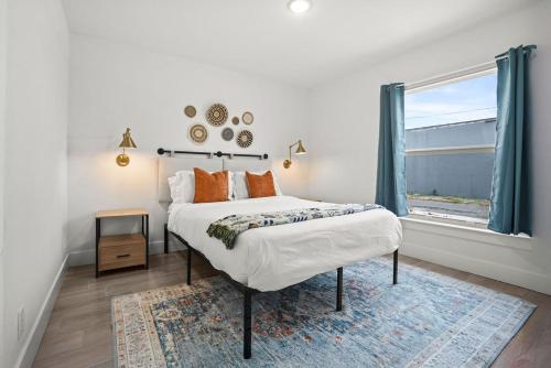 ein weißes Schlafzimmer mit einem Bett und einem Fenster in der Unterkunft Chic & Central 3br Mins To Downtown in West Palm Beach