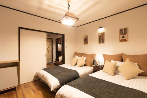 Un dormitorio con dos camas y un espejo. en Nihonbashi GRR5, en Osaka