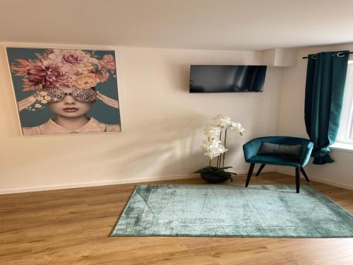 a living room with a blue chair and a rug at Holiday Home in Trois-Ponts near La Redoute in Trois-Ponts