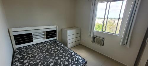 a small bedroom with a bed and a window at Apartamento - Básico Sossego in Porto Alegre