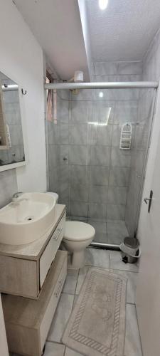 a bathroom with a sink and a toilet and a shower at Apartamento - Básico Sossego in Porto Alegre
